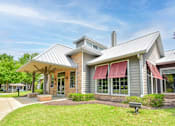 Thumbnail 30 of 43 - A modern house with a grey exterior and a red awning.