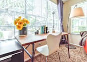 Thumbnail 10 of 43 - A room with a table, chairs, and a vase of flowers.