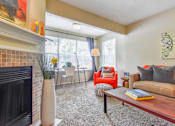 Thumbnail 11 of 43 - A living room with a fireplace, chairs, and a couch.