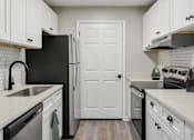 Thumbnail 22 of 43 - Kitchen with white cabinets and stainless steel appliances at Riverset Apartments modern apartments in Memphis, TN.