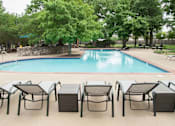 Thumbnail 42 of 43 - A pool surrounded by trees and chairs.