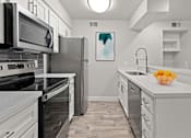 Thumbnail 3 of 27 - A kitchen with white cabinets and a black microwave.