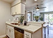 Thumbnail 6 of 27 - A kitchen with white cabinets and a marble countertop.