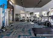 Thumbnail 15 of 27 - A gym with a variety of equipment including treadmills, weights, and exercise machines.