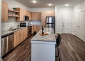 Thumbnail 16 of 36 - A  modern kitchen with wooden cabinets and granite countertops