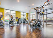 Thumbnail 10 of 24 - A gym with a variety of equipment including treadmills, weights, and exercise machines.