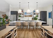 Thumbnail 11 of 20 - A modern kitchen with a dining table and chairs.