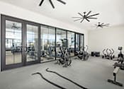 Thumbnail 12 of 20 - A gym with exercise equipment and a large window.
