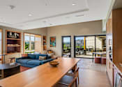 Thumbnail 28 of 50 - A modern living room with a long wooden table and a blue couch.