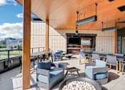 Thumbnail 35 of 50 - A modern outdoor seating area with wooden furniture and a flat screen TV.