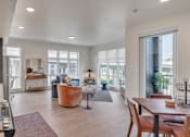 Thumbnail 10 of 50 - A modern kitchen with a large island and a dining area with a table and chairs.
