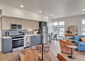 Thumbnail 13 of 50 - A modern kitchen with a dining area and a living room.