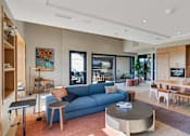 Thumbnail 12 of 50 - A modern living room with a blue sofa and wooden furniture.