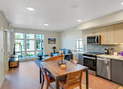 Thumbnail 17 of 50 - A modern kitchen with a dining table and chairs.