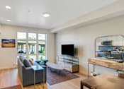 Thumbnail 16 of 50 - A modern kitchen with a grey sofa and a wooden table.