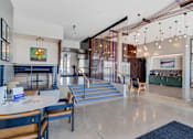 Thumbnail 37 of 50 - A modern lobby with a staircase and a bar area.