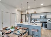 Thumbnail 1 of 50 - A modern kitchen with a dining table set for two.