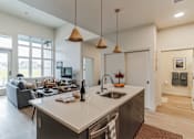 Thumbnail 3 of 50 - A kitchen with a large island and pendant lights.