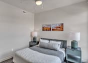 Thumbnail 14 of 50 - A bedroom with a bed, nightstands, and pictures on the wall.