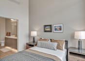 Thumbnail 32 of 50 - A bedroom with a bed, nightstands, and pictures on the wall.