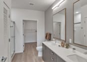 Thumbnail 23 of 50 - A bathroom with a toilet, sink, and mirror.