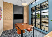 Thumbnail 12 of 48 - A conference room with a wooden table and chairs.
