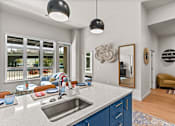 Thumbnail 32 of 48 - A modern kitchen with a large island and a view of the backyard.