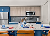 Thumbnail 27 of 48 - A kitchen with blue cabinets and a white refrigerator.