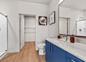 Thumbnail 29 of 48 - A bathroom with a toilet, sink, and mirror.