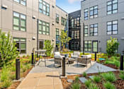 Thumbnail 24 of 48 - A courtyard with a table and chairs surrounded by buildings.
