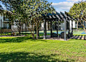 Thumbnail 22 of 26 - A black and white striped pergola is in the middle of a grassy area.