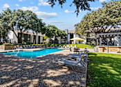 Thumbnail 17 of 26 - A pool surrounded by chairs and trees.