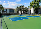 Thumbnail 19 of 26 - A tennis court with a green and blue surface.