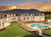 Thumbnail 33 of 34 - A resort with a swimming pool and a mountain in the background.