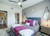 Thumbnail 9 of 33 - A bedroom with a bed, a ceiling fan, and a rug.