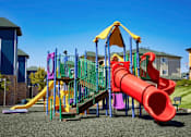 Thumbnail 28 of 33 - A playground with a red slide and a yellow canopy.