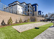 Thumbnail 32 of 33 - A modern building with a blue and white exterior is surrounded by a well-maintained lawn and a stone wall.