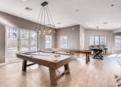 Thumbnail 16 of 33 - A billiard table is in the middle of a room with a pool table and a foosball table.