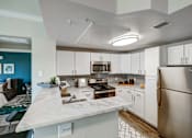 Thumbnail 2 of 33 - A kitchen with a marble countertop and stainless steel appliances.