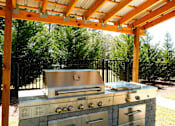 Thumbnail 16 of 48 - A stainless steel outdoor grill with a wooden pergola above it.