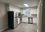 Thumbnail 4 of 48 - A kitchen with a black refrigerator and white cabinets.