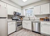 Thumbnail 2 of 48 - A kitchen with white cabinets and stainless steel appliances.