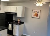 Thumbnail 15 of 20 - A kitchen with black appliances and white cabinets.