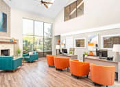 Thumbnail 11 of 20 - A room with orange chairs and a fireplace.