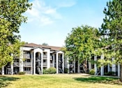 Thumbnail 1 of 20 - A large white building with columns and a balcony is surrounded by trees.
