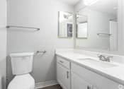 Thumbnail 20 of 20 - A white toilet sits next to a sink in a small bathroom.