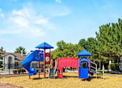 Thumbnail 5 of 20 - A playground with a blue slide, red slide, and a blue and red play structure.