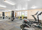 Thumbnail 6 of 20 - A gym with a variety of exercise equipment including treadmills, stationary bikes, and weight machines.