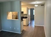 Thumbnail 7 of 20 - A kitchen with a sink and cabinets is visible through a window.