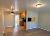 Thumbnail 8 of 20 - A room with a ceiling fan and wooden flooring.
